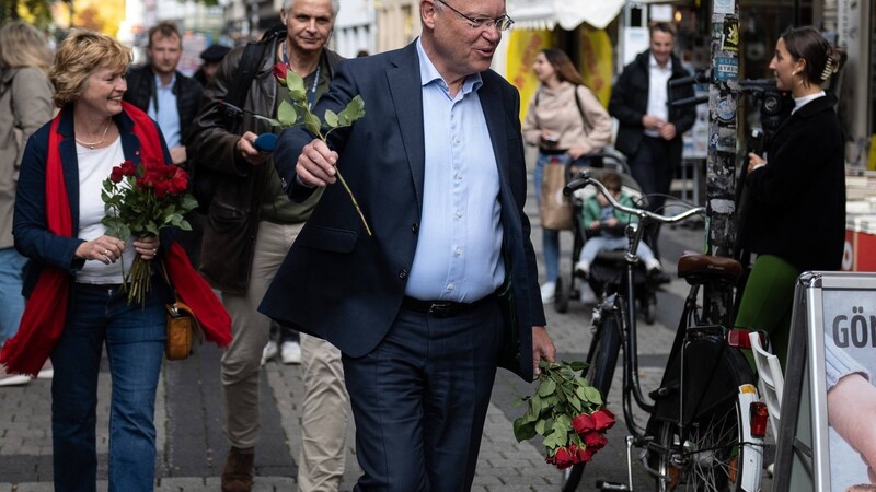 Stephan Weil, Spitzenkandidat der SPD für die Landtagswahlen in Niedersachsen, verteilt rote Rosen in der Göttinger Fußgängerzone.