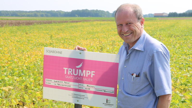 Voller Stolz zeigt Berthold Bauer das Schild mit dem Namen einer der beiden neu zugelassenen Sojabohnensorten seines Betriebs: Trumpf.