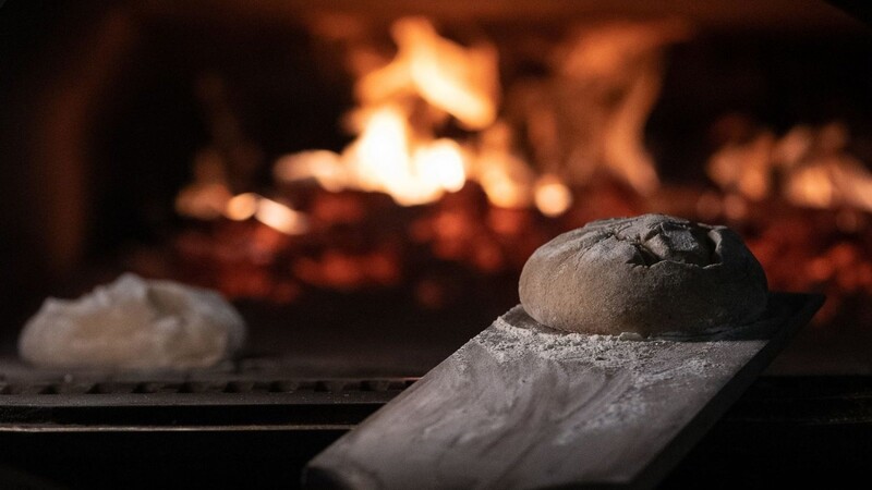Zwei Brotteige liegen in einem Feuerofen einer Bäckerei.