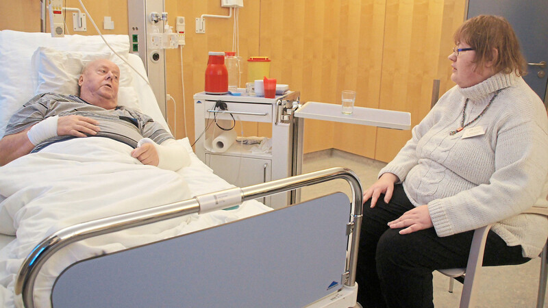 Besucherin Kerbeck an einem Krankenbett. Sie ist die Koordinatorin einer siebenköpfigen Gruppe, die ehrenamtlich Patienten besucht.