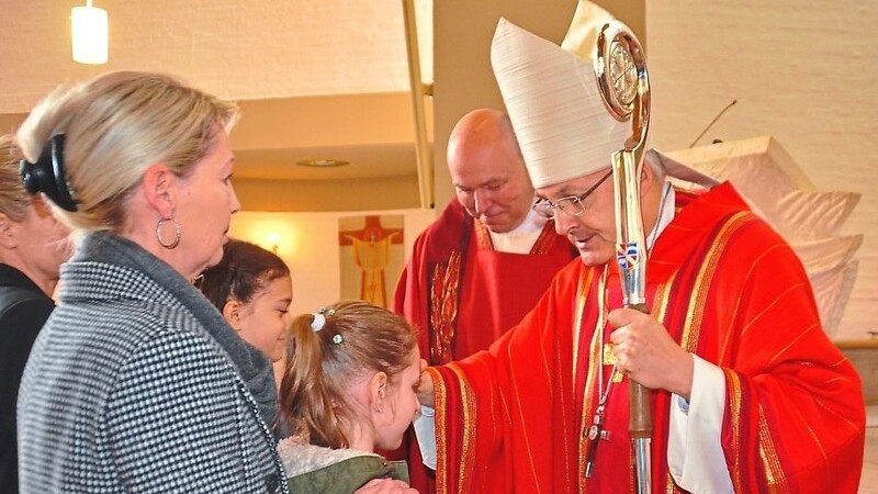 Der Bischof legt einem seiner Firmlinge die Hand auf.