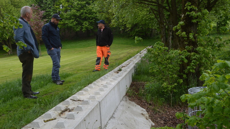 Sie begutachten die neue Schutzmauer aus Betonsteinen: Bürgermeister Josef Reff (links) mit den Bademeistern.