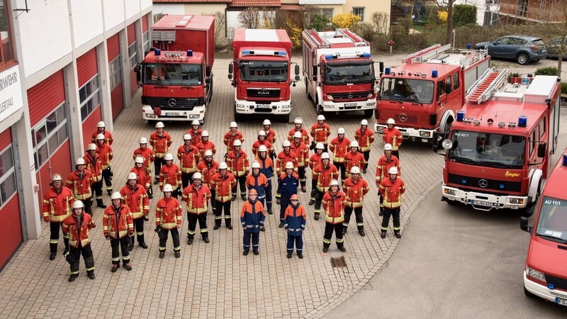Mitglieder der Auer Feuerwehr vor den Fahrzeugen der Stützpunktwehr.