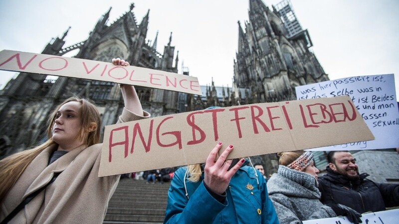Eine Frau protestiert am 10.01.2016 in Köln (Nordrhein-Westfalen) vor dem Hauptbahnhof und dem Dom gegen sexuelle Gewalt mit einem Plakat "Angstfrei leben". Nach den sexuellen Übergriffen auf Frauen in der Silvesternacht verstärkt die Polizei die Präsenz am Hauptbahnhof.