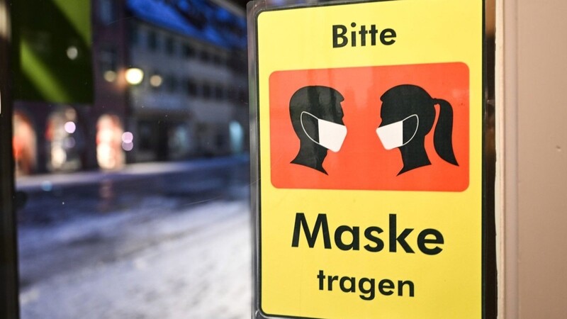 Ein Schild weist am Eingang eines Ladens auf die Maskenpflicht hin.