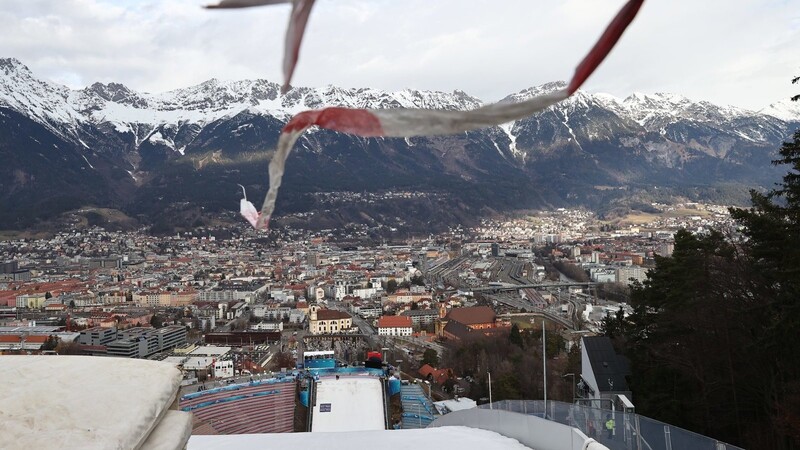 Eine Windfahne hängt vor dem Wettkampf an der Schanze am Bergisel, im Hintergrund ist Innsbruck zu sehen.