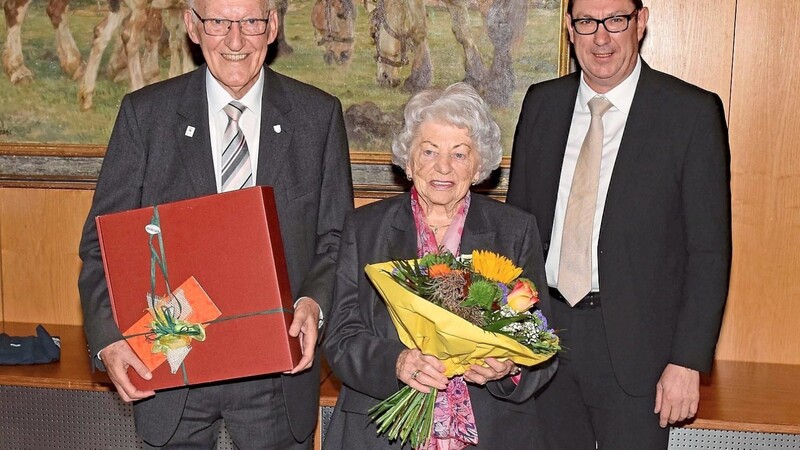 Landrat Martin Bayerstorfer (r.) überreichte dem langjährigen Kreisheimatpfleger Hartwig Sattelmair ein Geschenk, Ehefrau Elisabeth Kreuz-Sattelmair bekam Blumen.