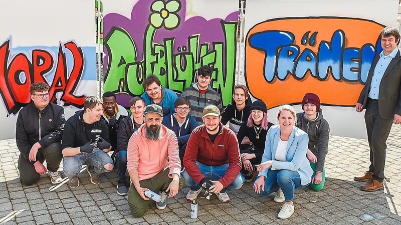 Die Stellvertreter des Schulleiters, Anton Kolbinger (links) und Hubert Ramesberger (rechts), die Initiatorin des Projekts, Simone Mittermeier (vorne rechts), und die Graffiti-Profis Michael Lotter und Oskar Schöttl freuten sich mit den jungen Künstlern über die gelungenen Graffiti-Kunstwerke.