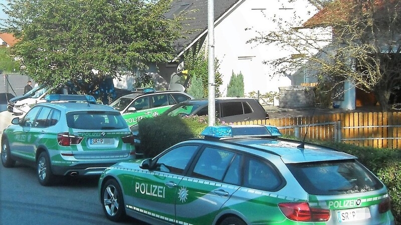 Mehrere Polizeifahrzeuge stehen am Mittwochnachmittag in der Nähe des Hauses in Oberzeitldorn,in dem sich das Verbrechen ereignet hat. Die Jalousien sind zugezogen.