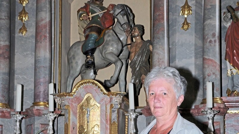 Kirchenpflegerin Erika Müller vor dem Hauptaltar mit der Statue des Heiligen Martins in der Kirche in Prunn.