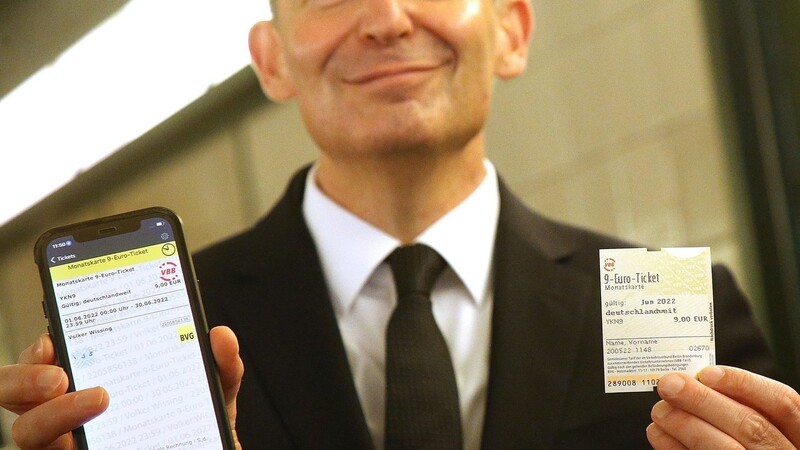 Bundesverkehrsminister Volker Wissing hält im Berliner U-Bahnhof Potsdamer Platz das 9-Euro-Ticket per App und als Fahrschein in Händen.