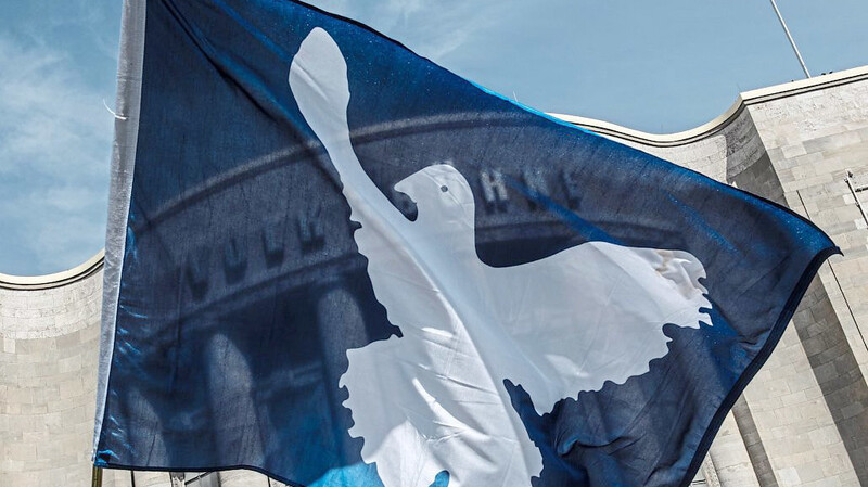 Symbol des Friedens: Eine Fahne mit einer Taube weht im April 2019 vor der Berliner Volksbühne, von wo der Ostermarsch startete.  Foto: Paul Zinken / dpa