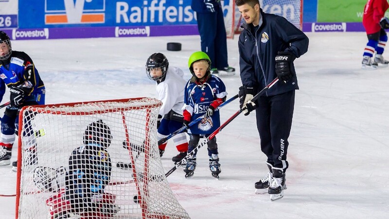 Tigers-Verteidiger James Bettauer stand zusammen mit einigen Teamkollegen mit den Kindern auf dem Eis.