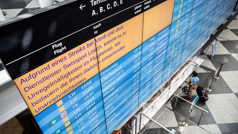 Eine Anzeigetafel am Münchner Flughafen weist auf Unregelmäßigkeiten im Flugbetrieb hin.