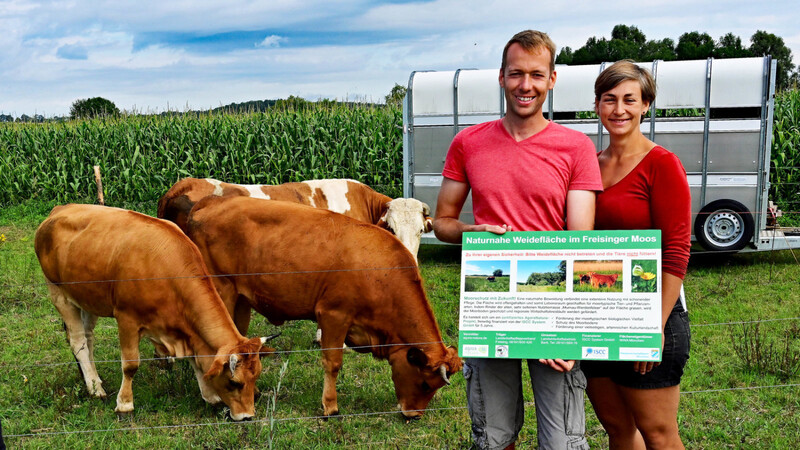 Martin und Evi Bartl mit dem Hinweisschild für die neue naturnahe Weidefläche im Freisinger Moos.