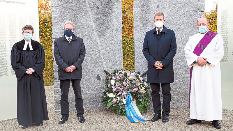 Pfarrer Klaus-Ulrich Bomhard (von links), Krankenhausdirektor Gerhard Schneider, Bezirkstagspräsident Olaf Heinrich und Diakon Slavko Radeljic-Jakic vor der Gedenkstätte.