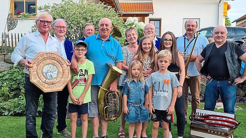 Reinhard Lubda im Kreis seiner Familie und der Musikanten, die ihm mit einer Scheibe zum 70. Geburtstag gratulierten.