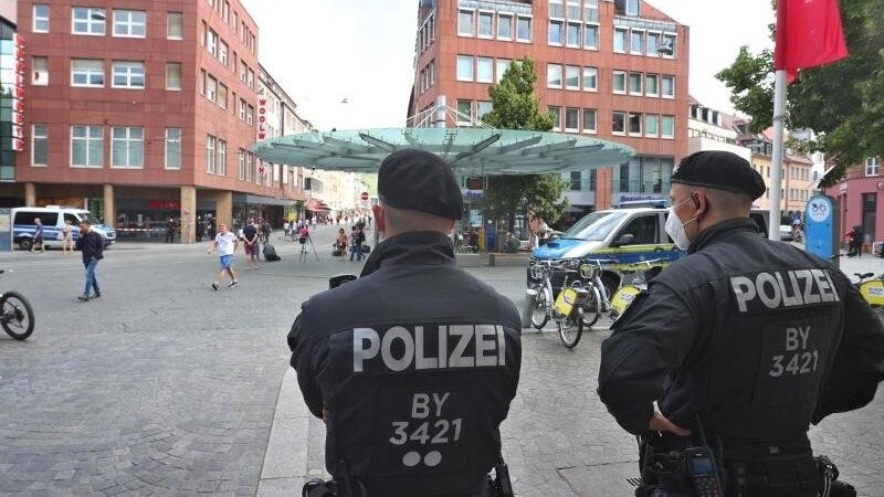 Polizisten stehen am Tatort in der Würzburger Innenstadt.