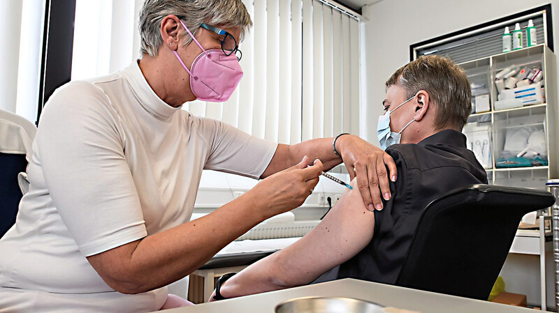 Eine Betriebsärztin bei der Impfung eines Mitarbeiters mit dem Impfstoff von Biontech/Pfizer.