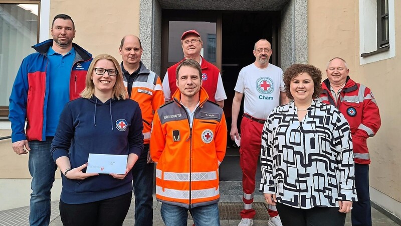 Bürgermeisterin Alexandra Riedl (vorne rechts) dankte Katastrophenschutzleiter Tobias Muhr (vorne, Mitte) und seinen ehrenamtlichen Rot-Kreuz-Kräften mit einem Spendenscheck für ihre monatelange Tätigkeit.