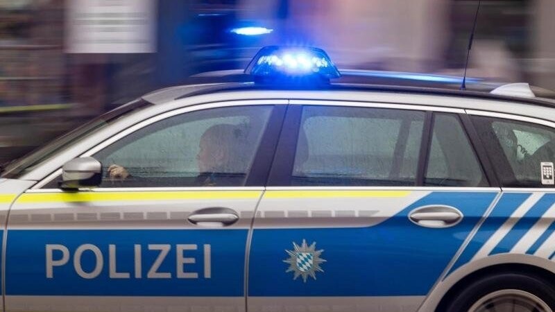 Ein Fahrzeug der bayerischen Polizei ist mit Blaulicht im Einsatz.
