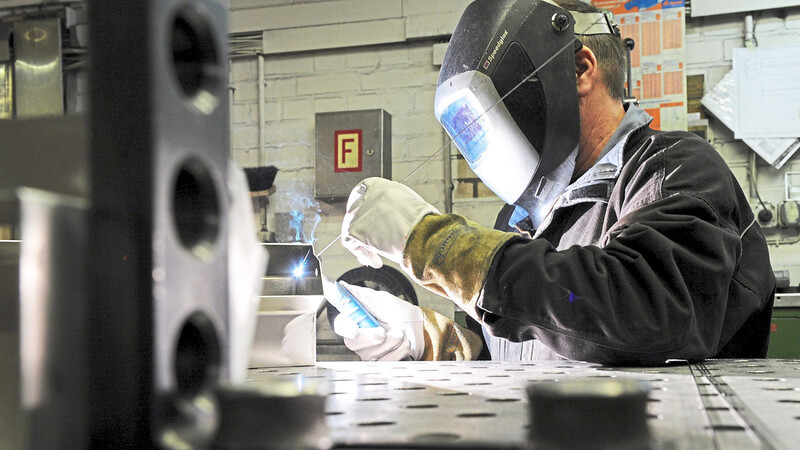 Ein Mitarbeiter eines metallverarbeitenden Betriebs schweißt an einem Werkstück. Die Stimmung in der Branche ist stark eingetrübt.