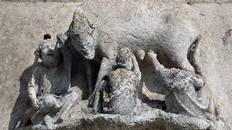 Die Regensburger "Judensau" zeigt drei Männer, die an den Zitzen eines Schweins saugen und ihm ins Ohr flüstern. Durch die spitzen Hüte seien sie als Juden gekennzeichnet. Die Skulptur erklärte Juden zu Feinden des Christentums, heißt es in einem neuen kommentierenden Text.