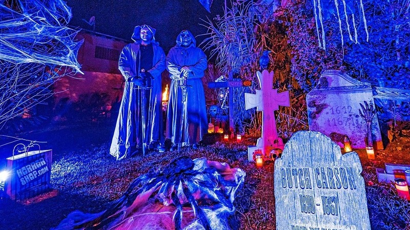 Es geht auch friedlich - mit künstlerischem Anspruch: Kostümierte Männer stehen am Halloween-Abend im einem gruselig dekorierten Garten in Straubing.