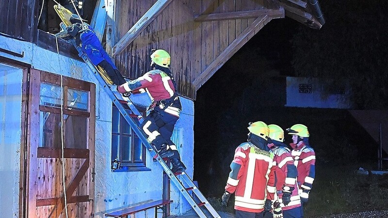 Rettungsaktion am Scheunendachboden: Die Feuerwehrleute holen den Übungs-Vermissten über eine Leiter vom Dachboden.