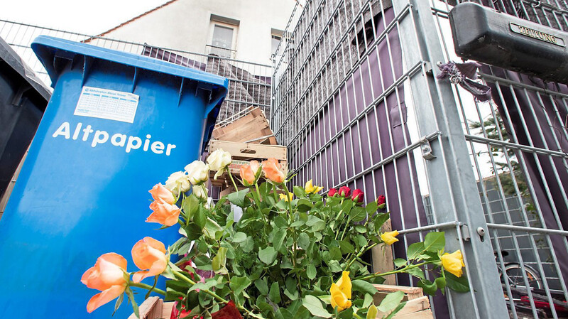 Blumen stehen vor dem Haus in Nürnberg, in dem am Wochenende durch einen Brand fünf Menschen getötet wurden.