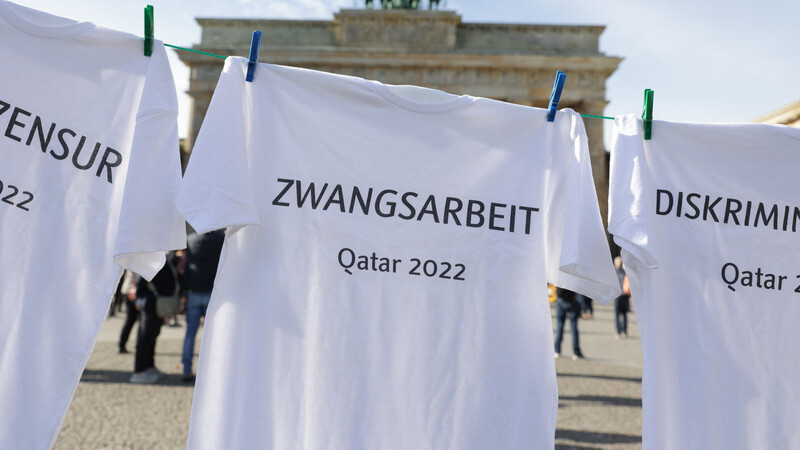 T-Shirts mit Begriffen wie Pressezensur, Zwangsarbeit, Diskriminierung und Justizwillkür hängen bei einer Aktion von Amnesty International im Zusammenhang mit der WM in Katar vor dem Brandenburger Tor.