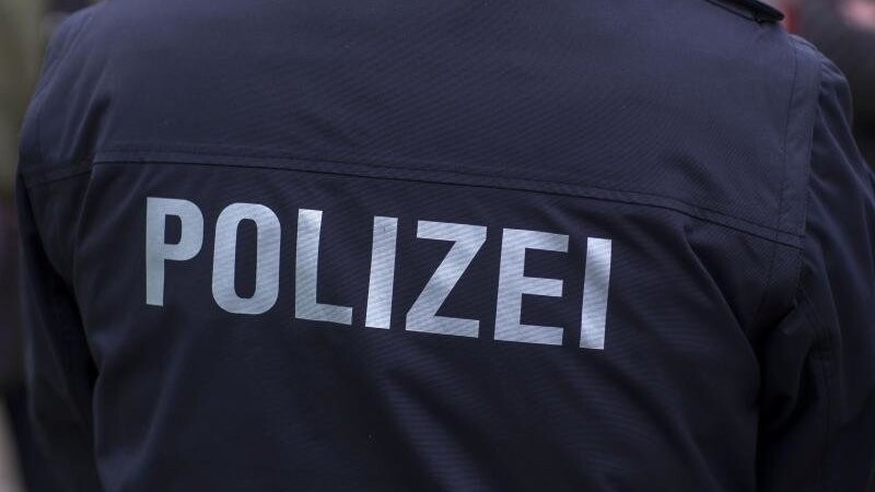 Der Schriftzug "Polizei" auf einer Uniform. Foto: Jens Büttner/zb/dpa/Archivbild