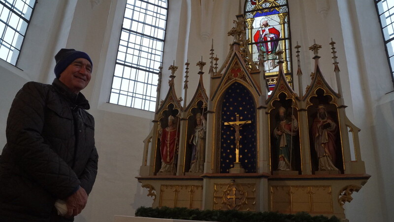 Georg Brams steht am Altar der Kirche St. Nikolaus in Herrnfelden. Den Altar hatte seine Mutter Therese davor bewahrt, zu Brennholz verarbeitet zu werden.