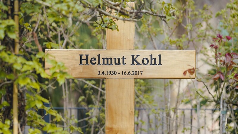 Auf einem schlichten Holzkreuz sind der Name und die Lebensdaten von Helmut Kohl schwarz eingraviert.