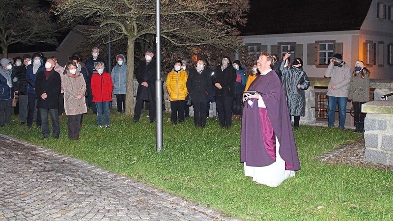 Mit Spannung erwarten Pfarrer Albert Hölzl und eine Schar von Kirchenbesuchern das erste Aufleuchten des großen Sterns.