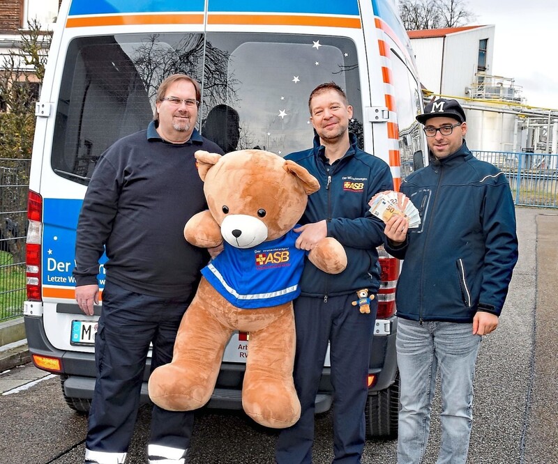 Manuel Förster (v. r.) bei der Spendenübergabe an Andreas Kotter und Björn Feldmann vom ASB-Wünschewagen München-Oberbayern. 