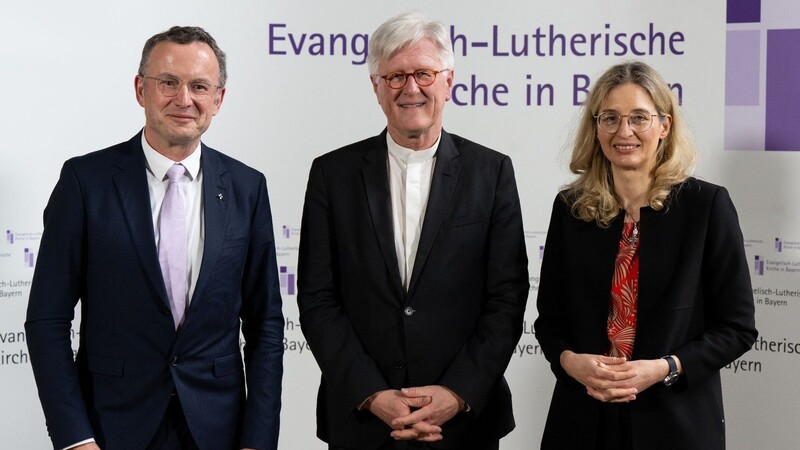 Christian Kopp (l) und Nina Lubomierski (r), Kandidaten für die Wahl zum Landesbischof oder Landesbischöfin, sowie Heinrich Bedford-Strohm (M), Landesbischof, nehmen an der Landessynode teil.