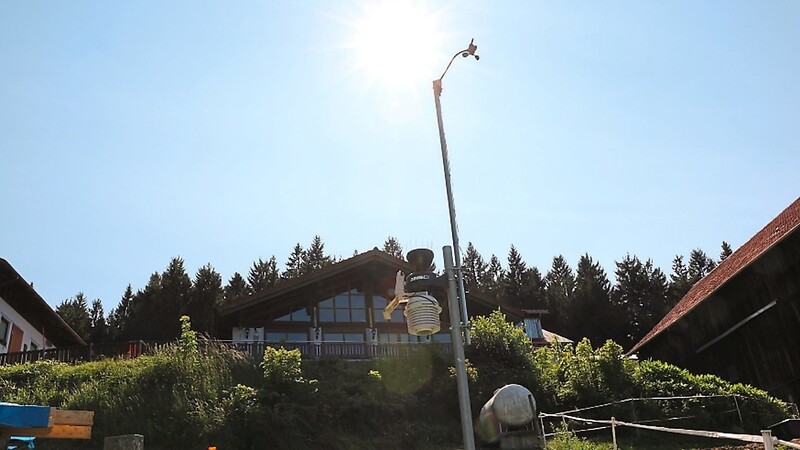 Die Sonne strahlt über dem Windmesser, der oben auf der knapp fünf Meter hohen Stange der Wetterstation angebracht ist.