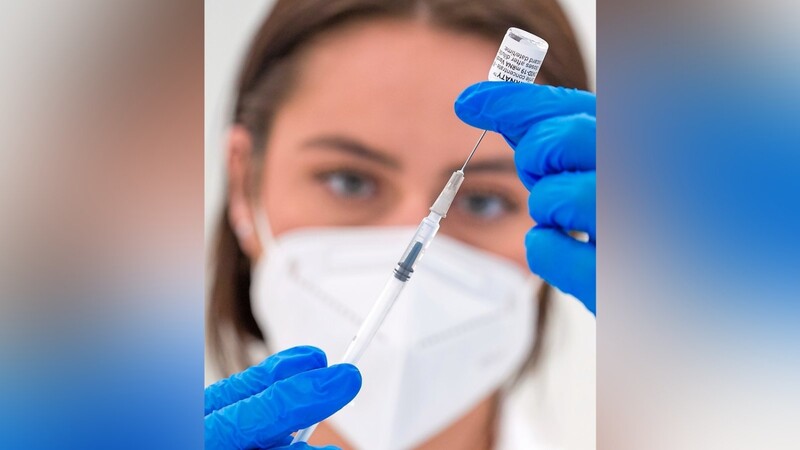 Eine pharmazeutisch-kaufmännische Angestellte bereitet eine Impfspritze mit dem Pfizer-BioNTech-COVID-19-Impfstoff vor.