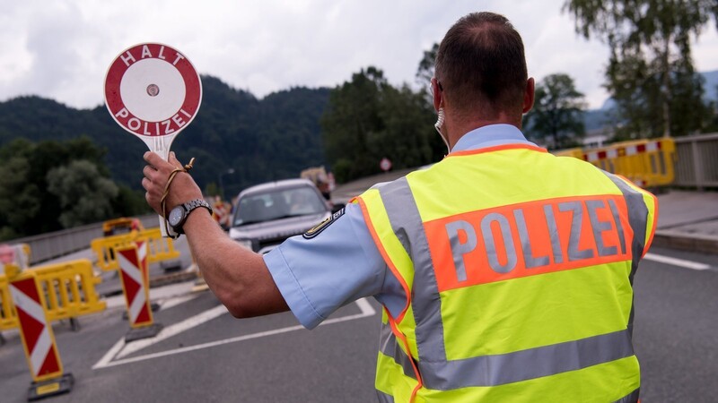 Polizisten kontrollieren an einer mobilen Kontrollstelle.