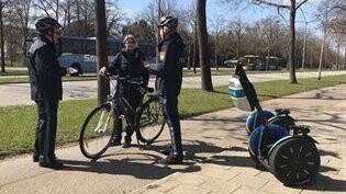 Die Polizisten in Regensburg sprechen mit einem Radfahrer über die Gefahren im Straßenverkehr.