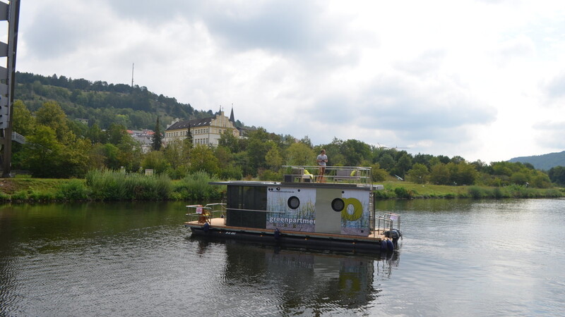 Das Hausboot schippert auf dem Main-Donau-Kanal bei Riedenburg vor der Kulisse des Jachenhausener Bergs mit Kloster "St. Anna".