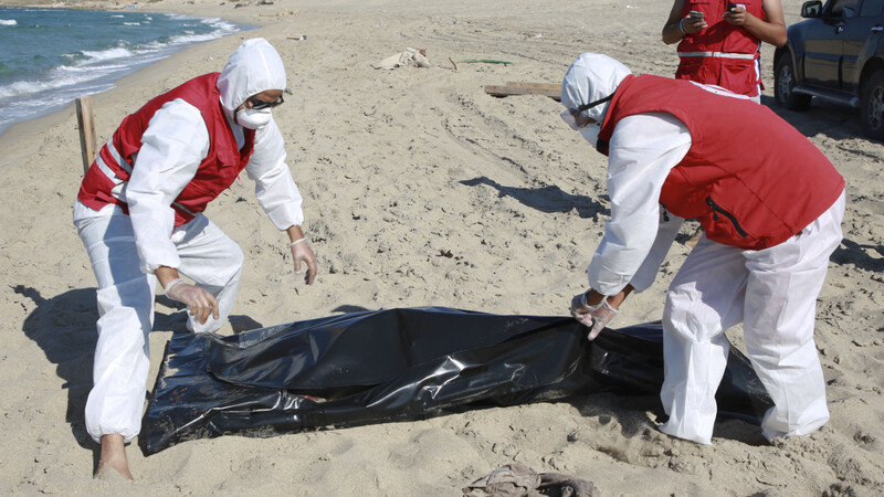 Libysche Mitarbeiter der Hilfsorganisation Roter Halbmond bergen die Leiche eines ertrunkenen Migranten.