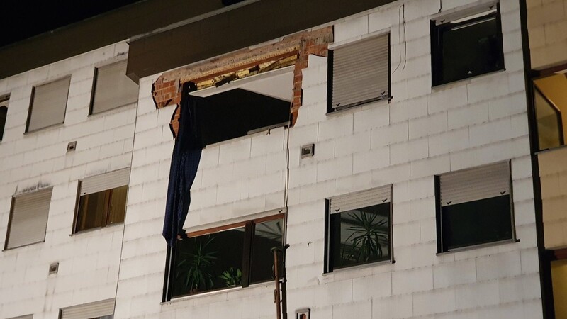Die Wucht der Explosion schleuderte ein Fenster und Teile der Hausverkleidung auf die Straße vor dem Mehrfamilienhaus, wo die Trümmer parkende Autos beschädigten.