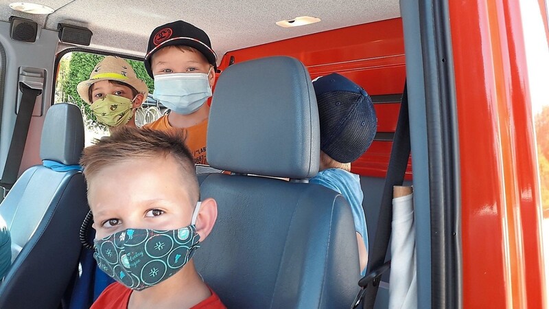 Trotz Maskenpflicht mit Spaß bei der Sache: die Kinder im Feuerwehrauto.