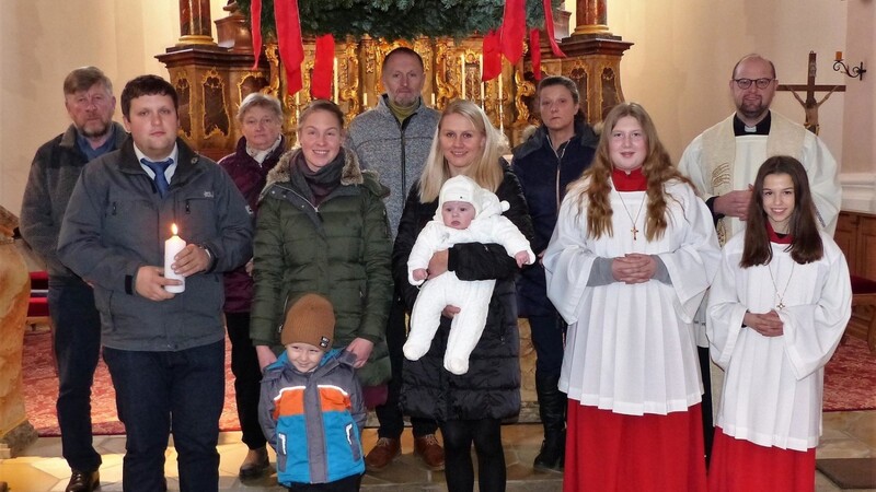 Täufling Lena Bucher mit Eltern, Brüderchen, Patin, Großeltern sowie Pfarrer Martin Schöpf und den beiden Ministrantinnen in der Pfarrkirche.