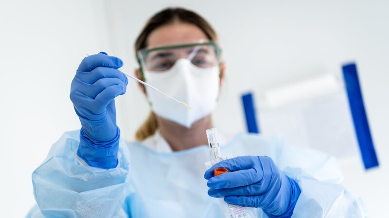 Eine Krankenschwester steckt in einem Schweizer Krankenhaus eine Probe mit dem Nasenabstrich eines Patienten, der auf das neuartige Coronavirus getestet wird, in einen Behälter. Nach den Landkreisen Cham und Regensburg ist jetzt auch eine Frau aus Geiselhöring infiziert.