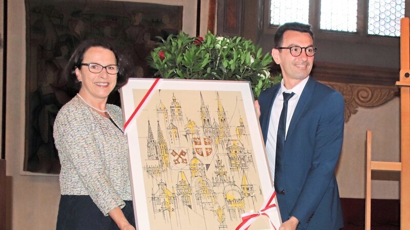 Bürgermeisterin Gertrud Maltz-Schwarzfischer überreicht Jérôme Auslender das Gastgeschenk.