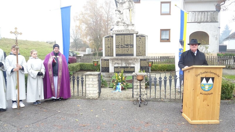 Dritter Bürgermeister Siegfried Müller bei der Gedenkrede am Kriegerdenkmal, links Kurat Thomas Weinzierl.