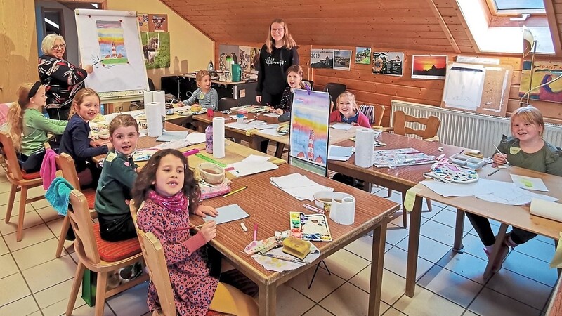 Einen Leuchtturm sollen die Kinder im Malkurs von Renate Fuchs (Im Hintergrund am Flipchart) als Aquarell zu Papier bringen - eine anspruchsvolle Aufgabe.